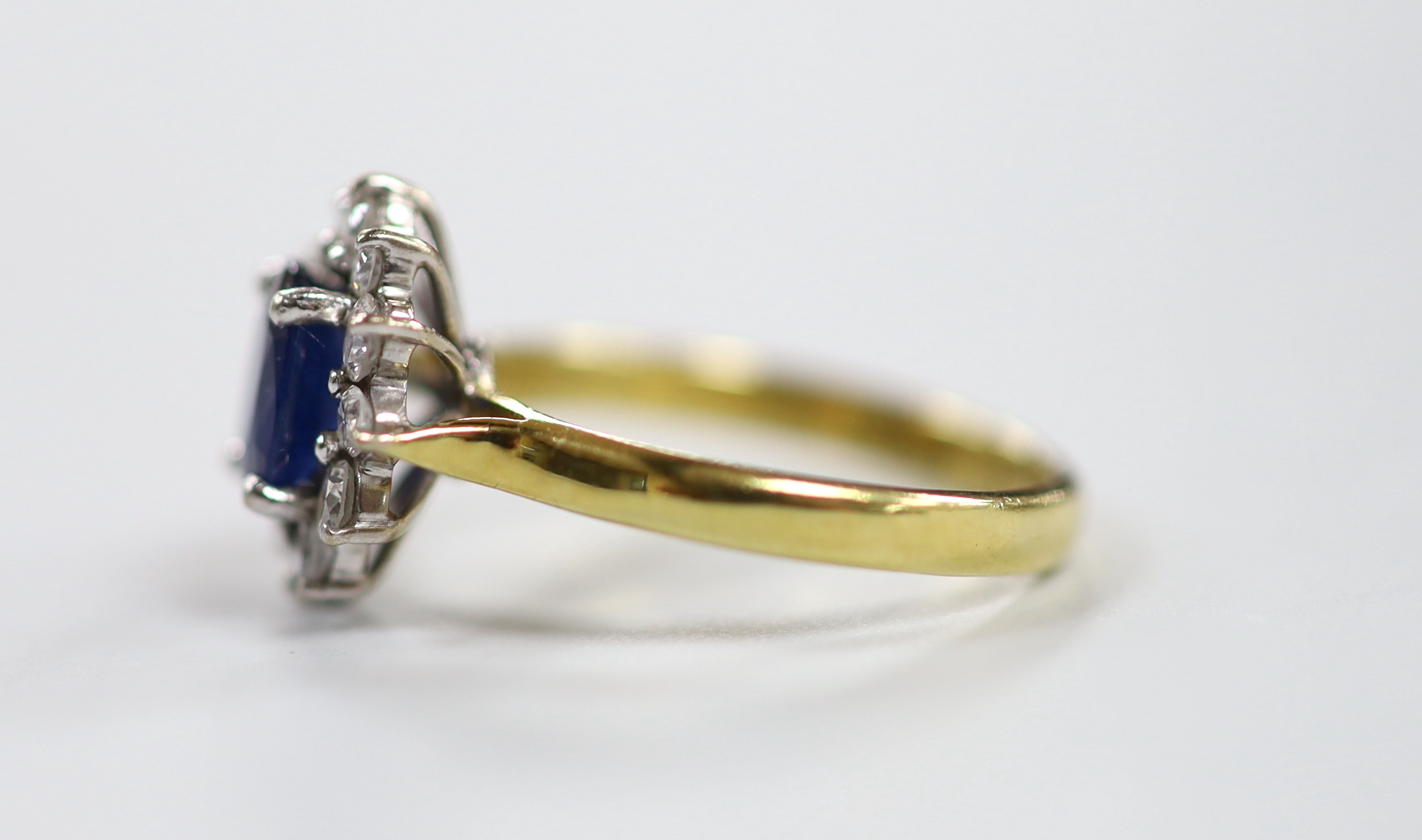 A modern 18ct gold sapphire and diamond set oval cluster ring, size J, gross weight 3.2 grams.